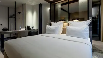 a bedroom with a large white bed and a desk at Porto Royal Bridges Hotel in Porto