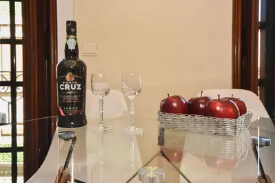 a bottle of wine and glasses on a table with apples at Azulejos Duplex Apartment - Porto Downtown in Porto