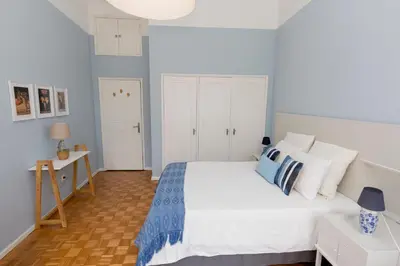 a bedroom with a white bed with blue and white pillows at Porto Haven - Vintage Apartment in Downtown in Porto