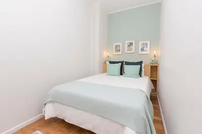a bedroom with a large white bed with blue pillows at Porto Haven - Vintage Apartment in Downtown in Porto
