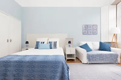 a white bedroom with a bed and a couch at Porto Haven - Vintage Apartment in Downtown in Porto