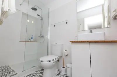 a white bathroom with a toilet and a glass shower at Porto Haven - Vintage Apartment in Downtown in Porto