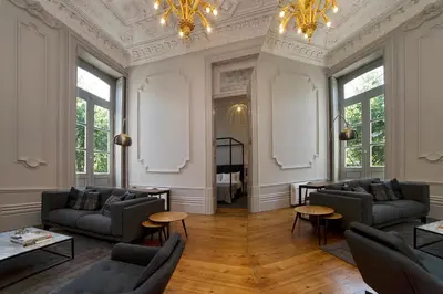 a living room with couches and tables and windows at Oporto Royal Apartment - Solar da Avenida in Porto
