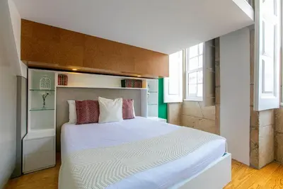 a bedroom with a large white bed with two windows at Casa da Cordoaria by Oporto Soul in Porto