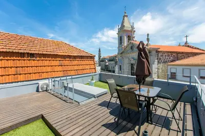 a wooden deck with a table and chairs on a balcony at Casa da Cordoaria by Oporto Soul in Porto