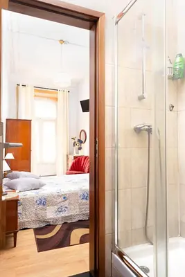 a bathroom with a shower and a bed and a tub at Almada Guest House in Porto