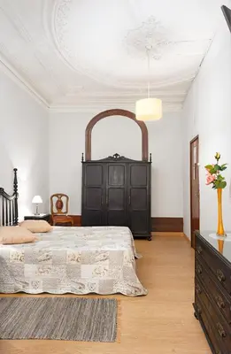 a bedroom with a large bed and a dresser at Almada Guest House in Porto