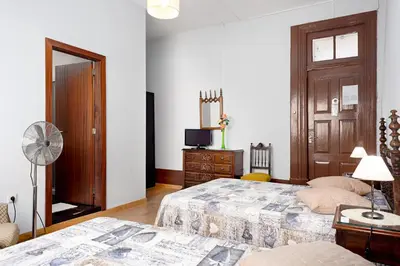 a bedroom with two beds and a fan at Almada Guest House in Porto