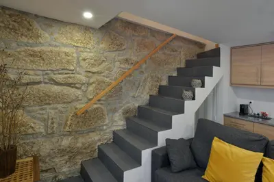 a staircase in a house with a stone wall at Oporto Memory Houses 7 in Porto
