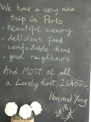a chalkboard with a sign with white flowers on it at Oporto Memory Houses 7 in Porto