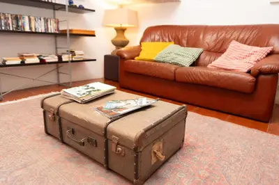 a living room with a brown leather couch and a trunk at Oporto Sky Hostel in Porto