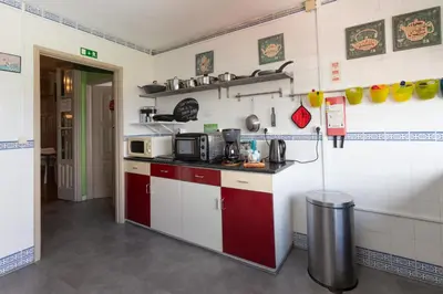 a kitchen with red and white cabinets and a microwave at Oporto Sky Hostel in Porto