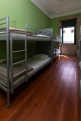 two bunk beds in a room with a wooden floor at Oporto Sky Hostel in Porto