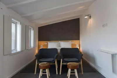 a room with two chairs and a bed at Oporto Design Attic - Solar da Avenida in Porto
