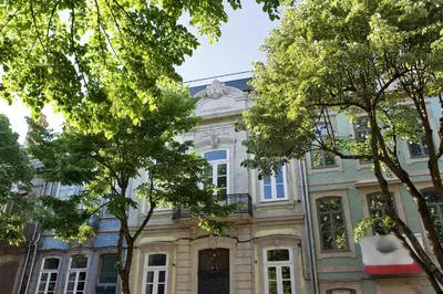a large building with trees in front of it at Oporto Design Attic - Solar da Avenida in Porto
