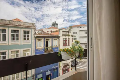 a white bedroom with a large white bed with colorful pillows at Santa Catarina Modern Flat in Porto