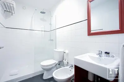 a bathroom with a toilet and a sink and a mirror at Calacatta Housing in Porto
