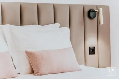 a bed with white pillows and a brown headboard at Calacatta Housing in Porto