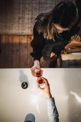 a woman is holding a glass of wine in a bath tub at Calacatta Housing in Porto