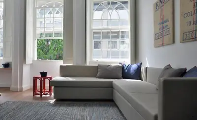 a living room with a couch and two windows at Spot Apartments Casa Januario in Porto