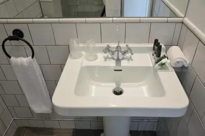 a white sink in a white tiled bathroom at Spot Apartments Casa Januario in Porto