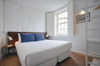 a white bed with blue pillows in a room at Spot Apartments Casa Januario in Porto