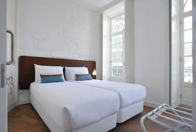 a bedroom with a large white bed and a chair at Spot Apartments Casa Januario in Porto
