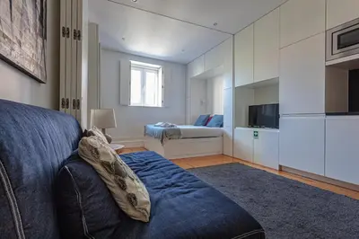 a living room with a blue couch and a bedroom at Citybreak-Apartments Poveiros in Porto