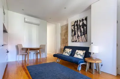 a living room with a blue couch and a table at Citybreak-Apartments Poveiros in Porto