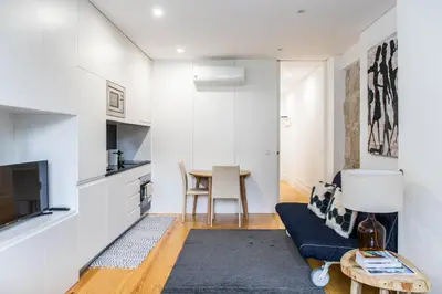 a living room with a blue couch and a table at Citybreak-Apartments Poveiros in Porto