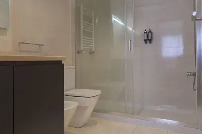 a bathroom with a toilet and a glass shower at Republica Deluxe Apartment in Vila Nova de Gaia