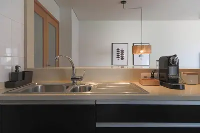 a kitchen counter with a sink and a coffee maker at Republica Deluxe Apartment in Vila Nova de Gaia