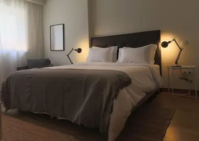 a bedroom with a large bed with two lamps on it at Republica Deluxe Apartment in Vila Nova de Gaia