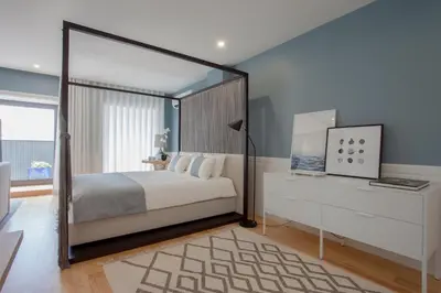 a bedroom with a canopy bed and a white dresser at Liiiving in Porto | Downtown Luxury Studio in Porto