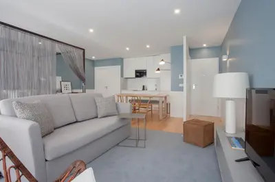 a living room with a white couch and a kitchen at Liiiving in Porto | Downtown Luxury Studio in Porto