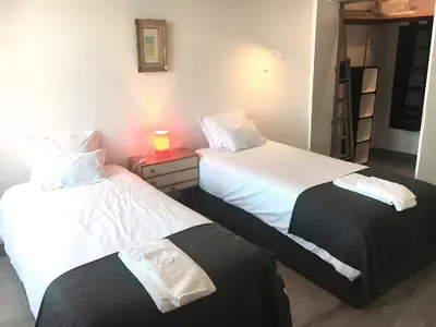 two beds in a room with a candle on a night stand at Casa da Catedral II in Porto