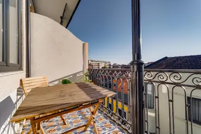 a wooden bench on the balcony of a building at Nomad's Netto & Subway in Porto
