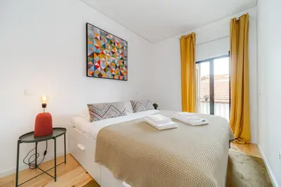 a white bedroom with a bed and a window at Nomad's Netto & Subway in Porto