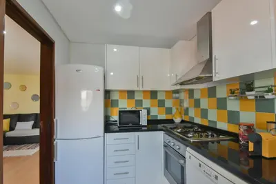 a kitchen with white cabinets and a white refrigerator at Clerigos Old Town Apartment in Porto