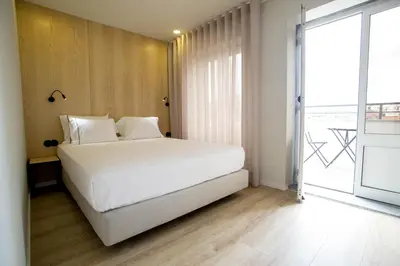 a bedroom with a white bed and a large window at The Gate Porto in Porto