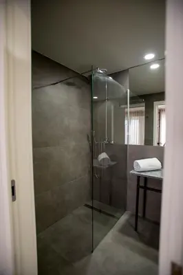 a bathroom with a shower with a glass door at The Gate Porto in Porto