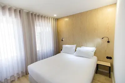 a white bed with white pillows in a bedroom at The Gate Porto in Porto