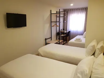 a hotel room with two beds and a flat screen tv at The Gate Porto in Porto