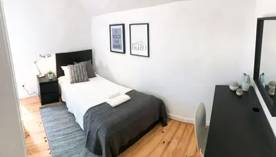 a small bedroom with a bed and a table at Porto Luxury Apartments in Vila Nova de Gaia