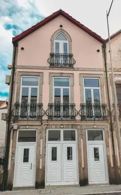 a pink building with white doors and windows at Porto Luxury Apartments in Vila Nova de Gaia