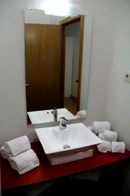 a bathroom with a sink and a mirror and towels at 12 Short Term in Porto