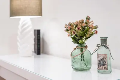 two bottles and a vase with flowers on a counter at GuestReady - Amaryllis Apartment in Porto