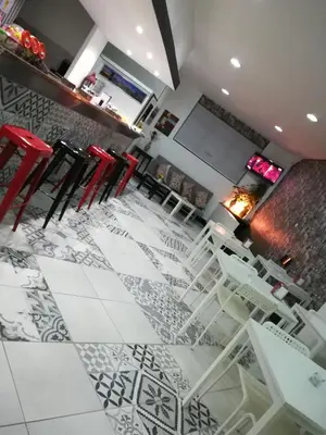 a bar with red chairs and a white floor at Hotel Cristo Rei in Porto