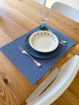 a table with a plate and a glass on a blue place mat at Vitral House of Art District in Porto