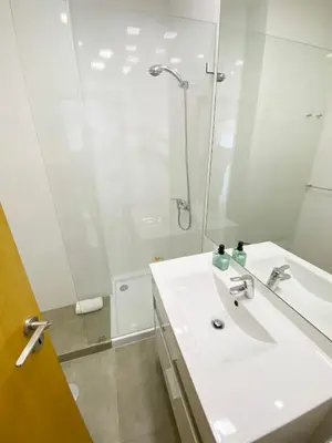a white bathroom with a sink and a shower at Vitral House of Art District in Porto
